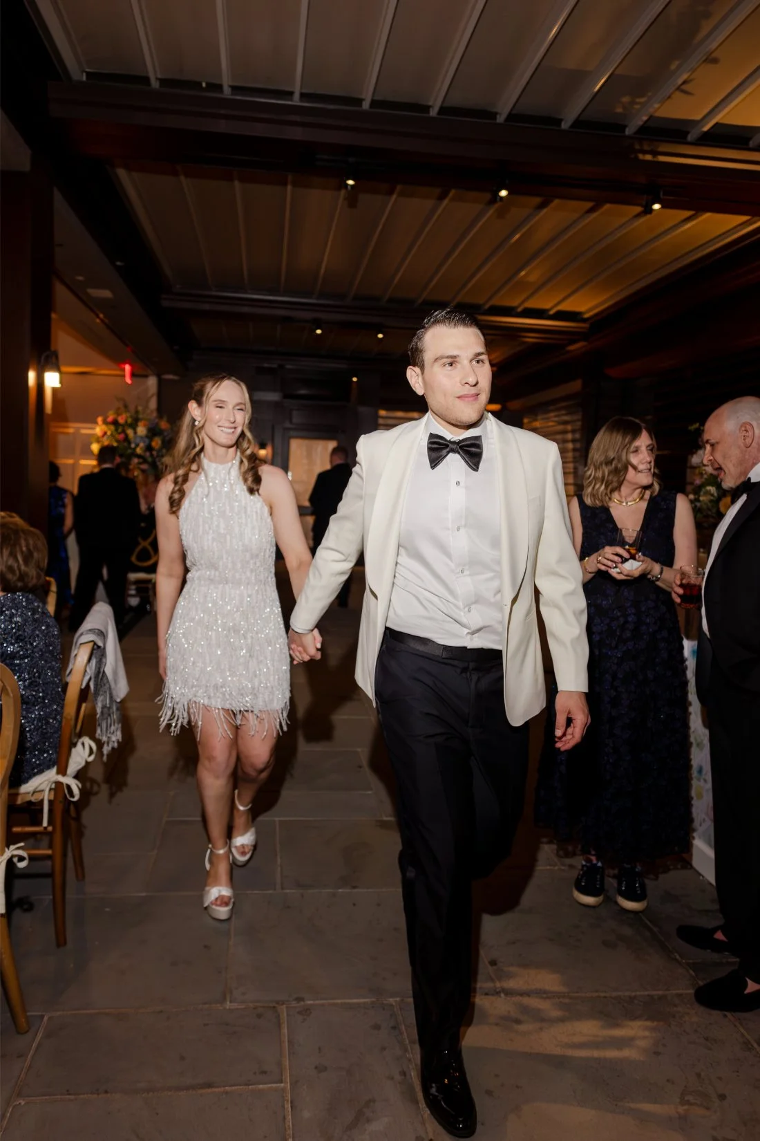 Bride and groom entering their Quaker Ridge Golf Club wedding reception in their second looks.