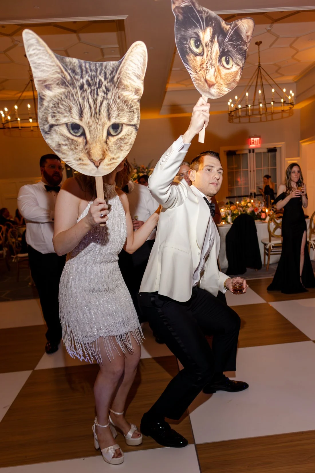 Bride and groom playfully holding cat cutouts at their Quaker Ridge Golf Club wedding.