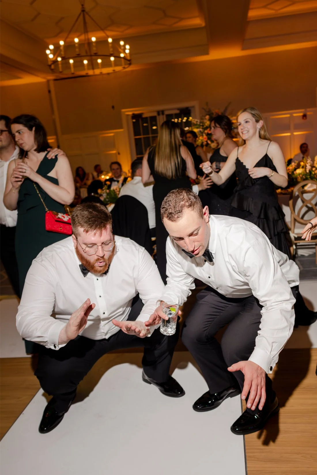 Wedding guests dancing together on the packed reception dance floor.