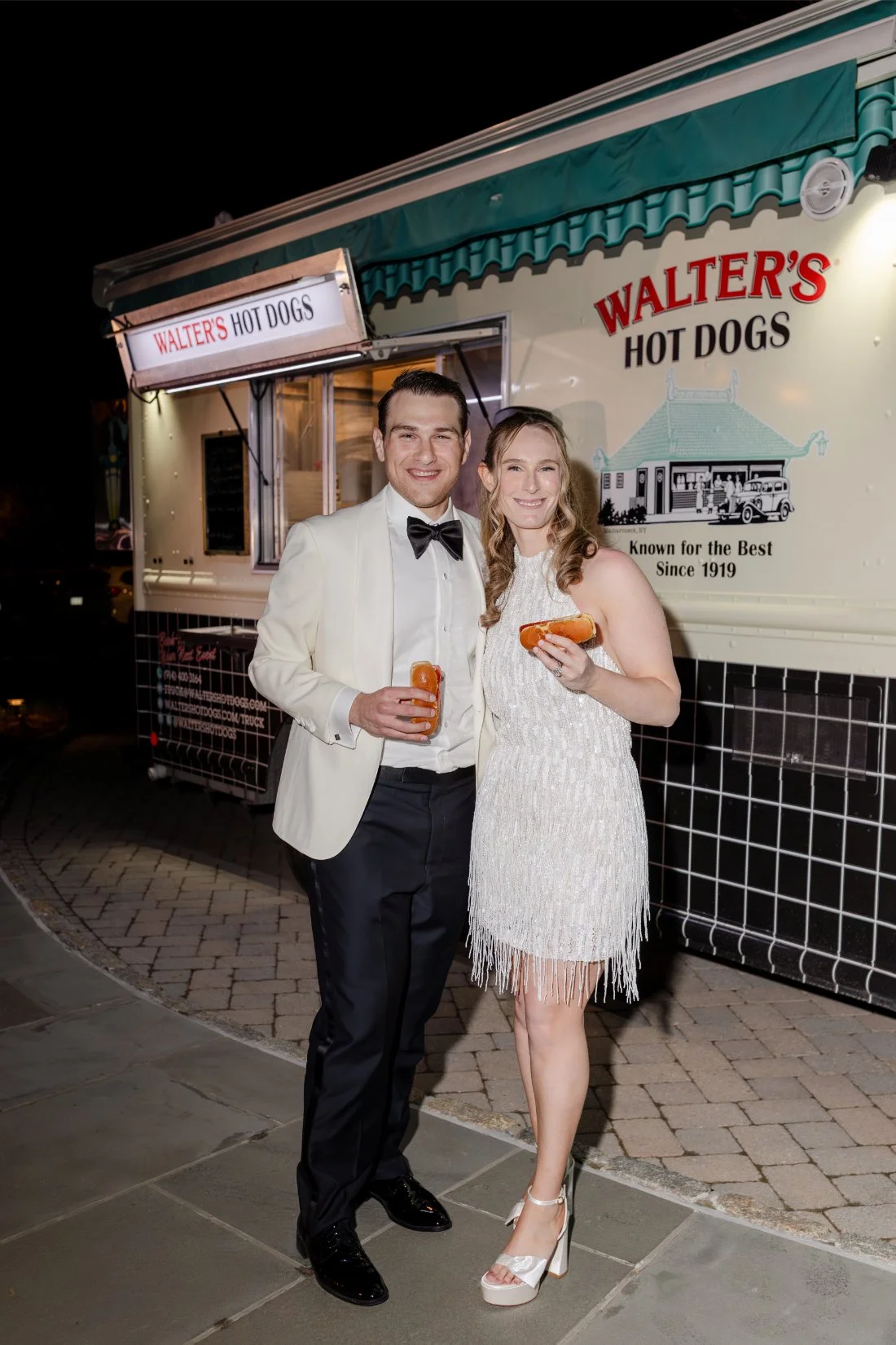 Newlyweds posing with Walter’s Hot Dogs during their Quaker Ridge Golf Club wedding after-party.