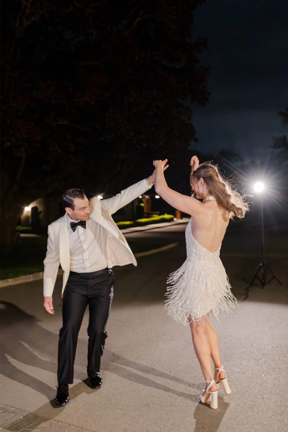 Amanda and Ethan dancing outside at night during their Quaker Ridge Golf Club wedding celebration.