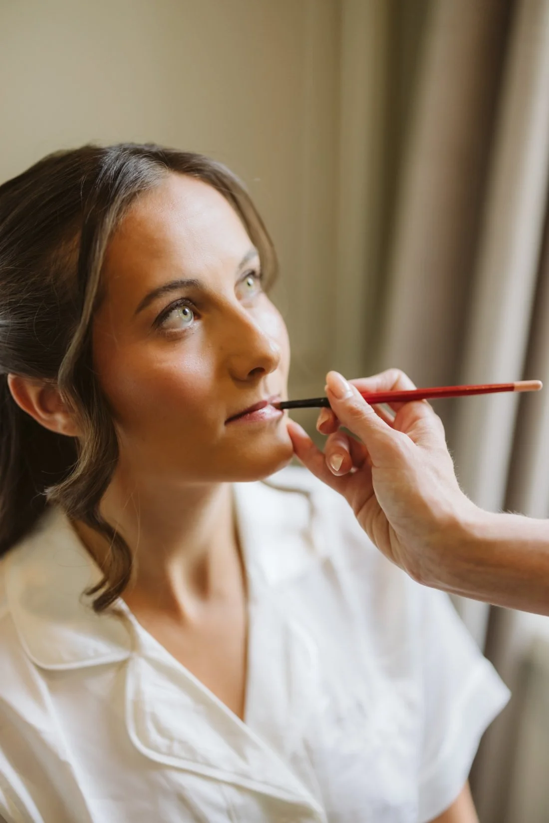 Bride having her makeup professionally applied while getting ready for her Tappan Hill Mansion wedding.