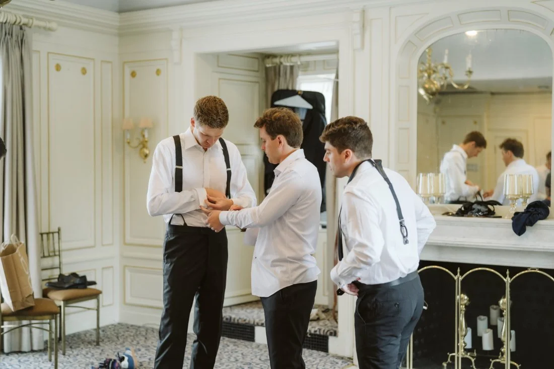 Groom getting ready with his groomsmen in an elegant suite before his Tappan Hill Mansion wedding ceremony.