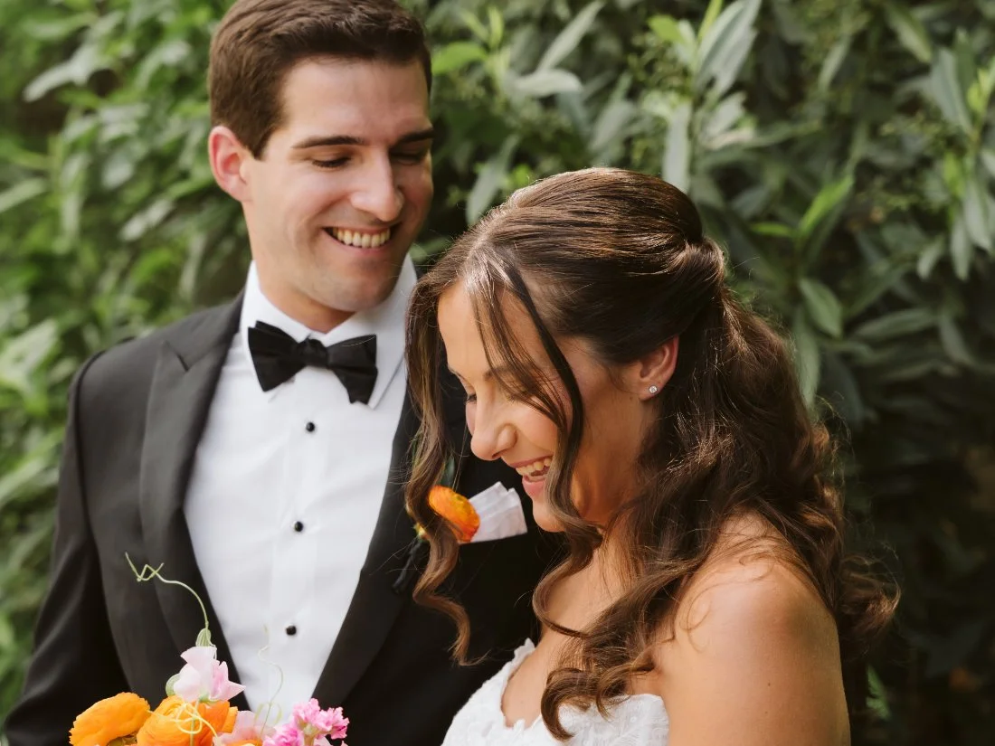 groom smiles lovingly at his bride during vow reading