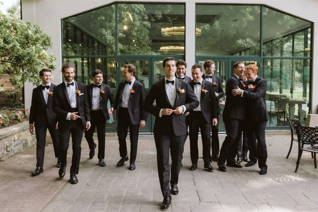 groomsman walking together toward the ceremony space 