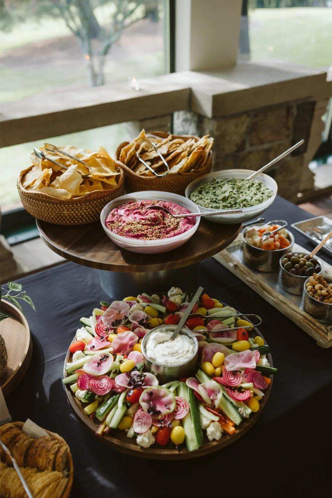 Tappan Hill Mansion wedding cocktail hour food display featuring colorful fresh vegetables, dips, tortilla chips, crackers, and assorted appetizers.