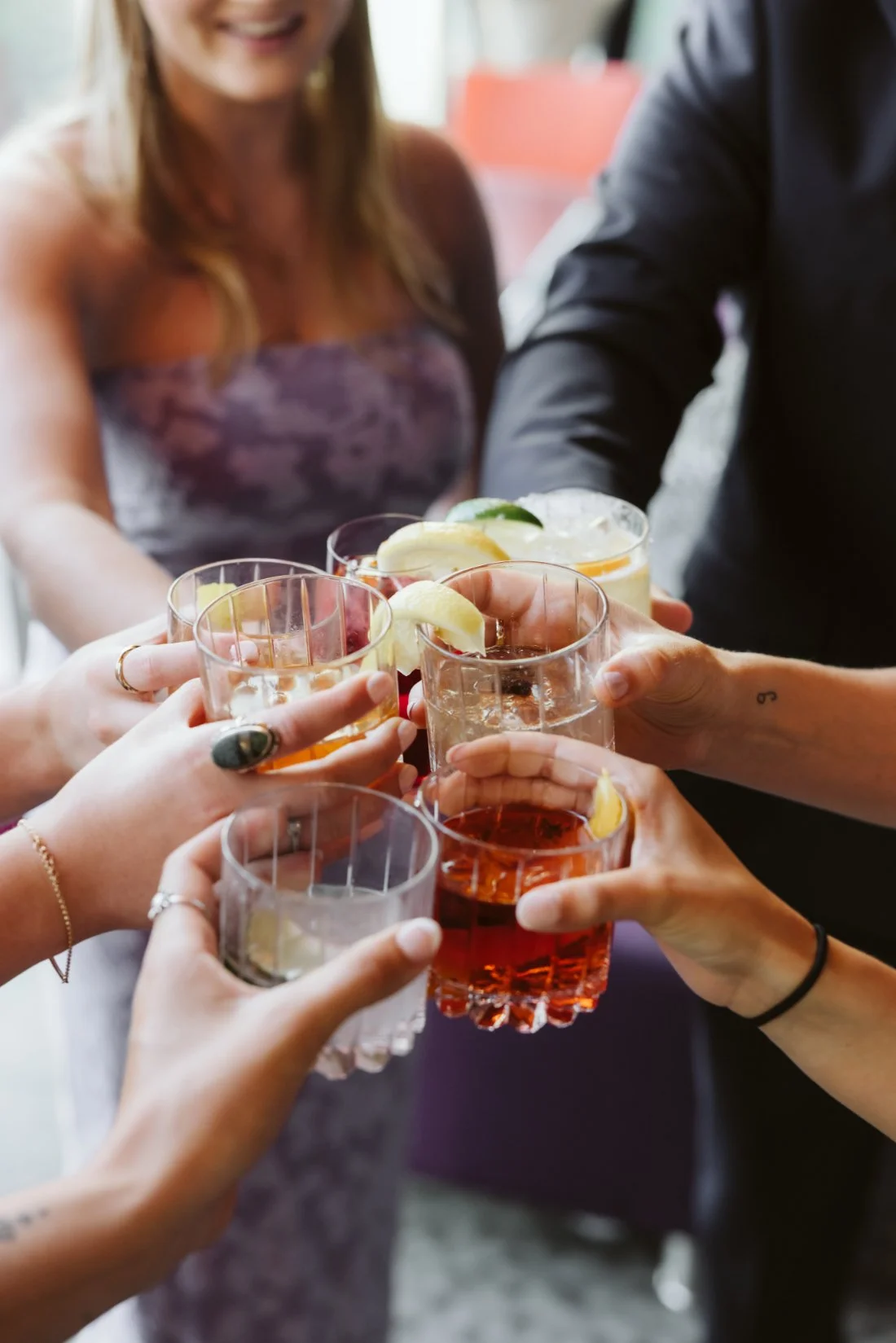 Guests raise their cocktail glasses in a celebratory toast before a summer Tappan Hill Mansion wedding.
