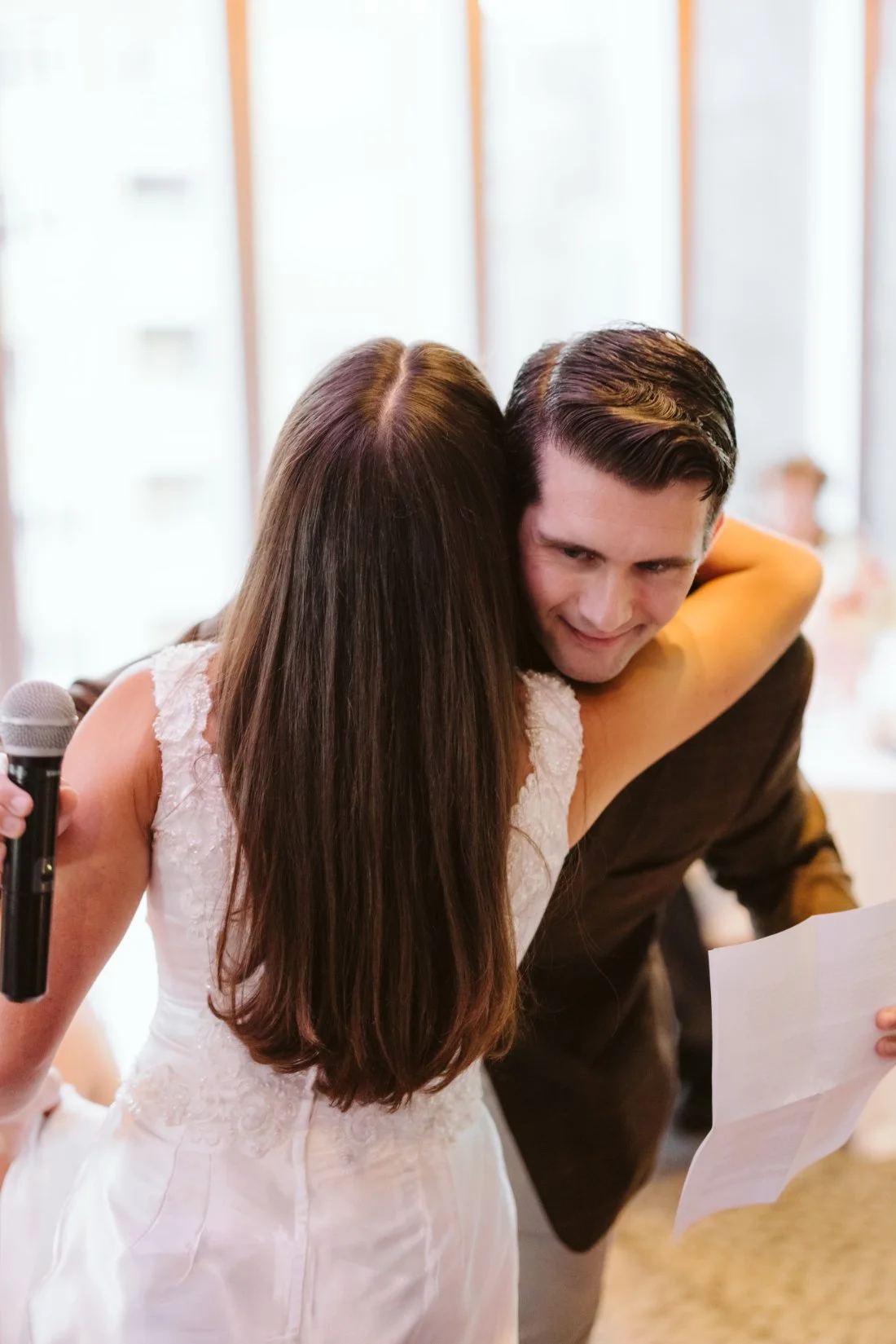 Bride embraces a family member during a rehearsal dinner speech before her Tappan Hill Mansion wedding.