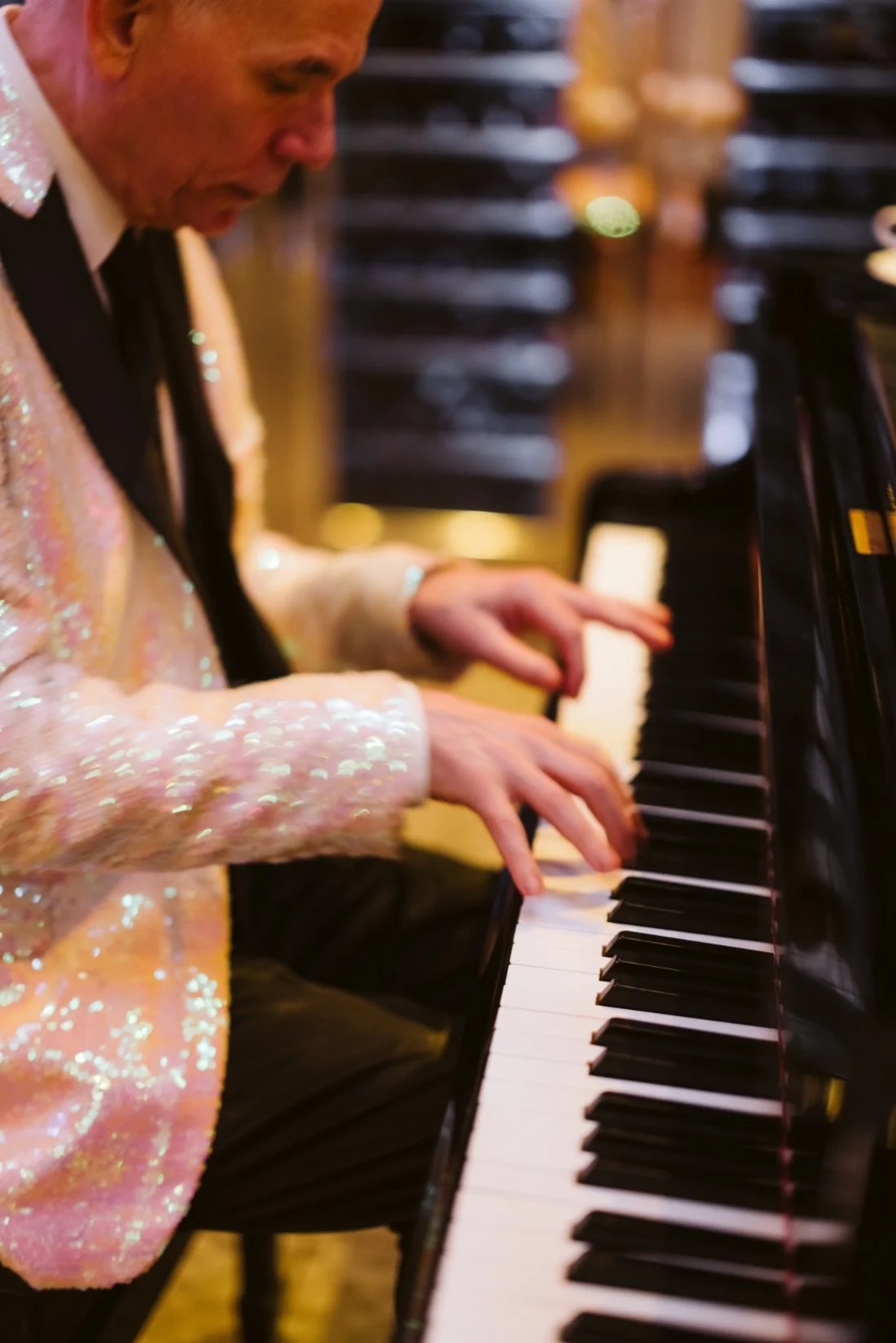 Pianist performs in a shimmering pink jacket during an elegant rehearsal dinner at Robert restaurant in New York City.