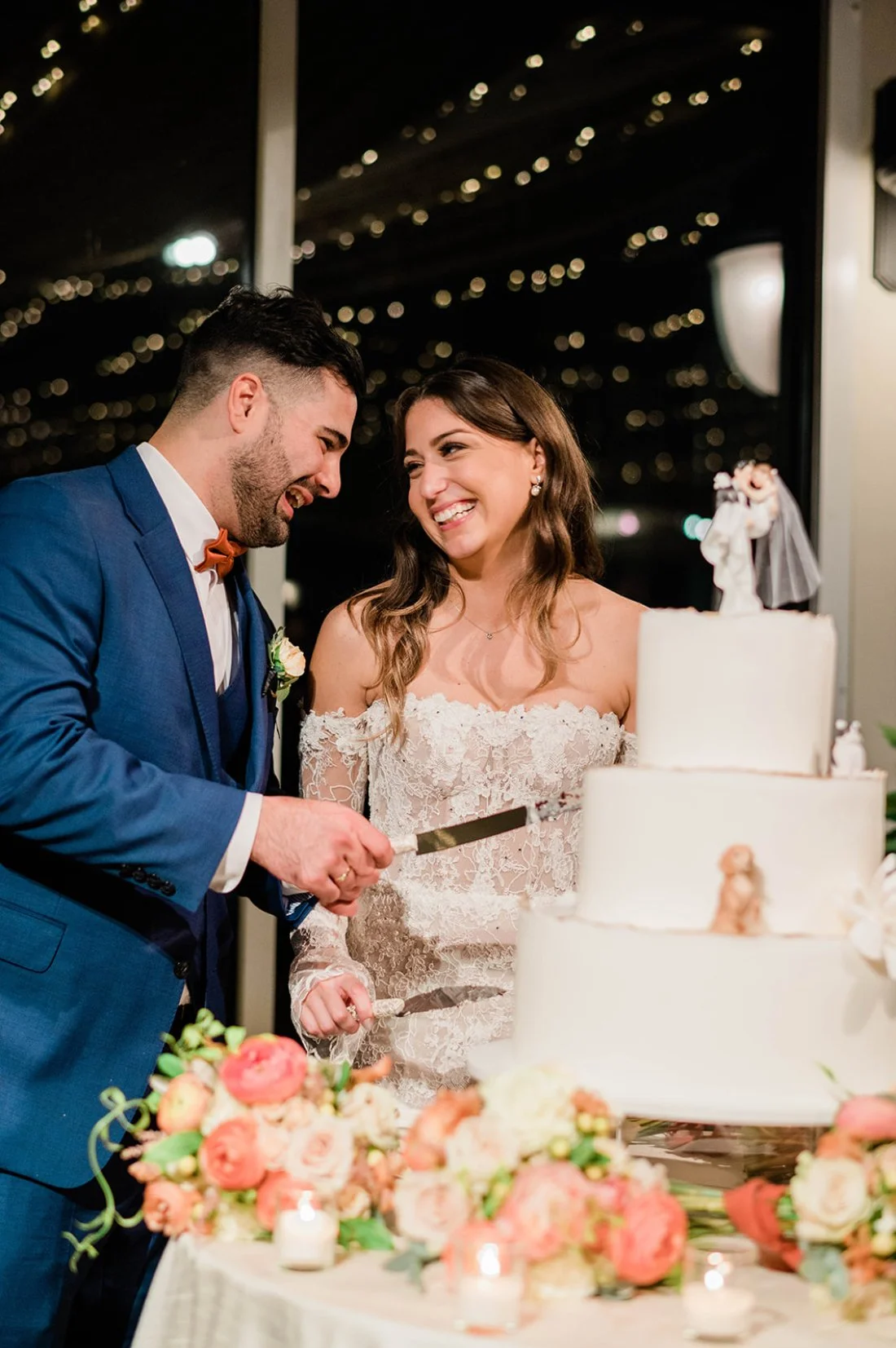 Bride and groom cutting a tiered wedding cake during their reception, reflecting how clear wedding priorities create joyful, stress free moments.