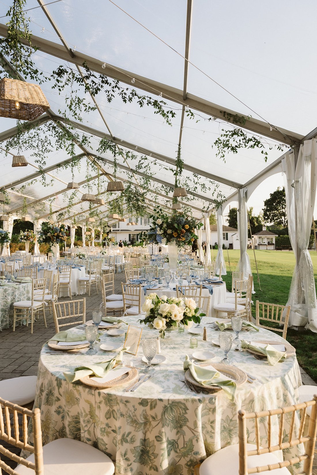 Elegant outdoor tented reception with floral linens and hanging greenery, designed around thoughtful wedding priorities that shape the guest experience.