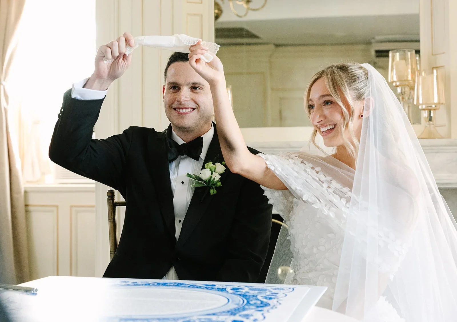 Bride and groom holding a traditional Jewish cloth together during their jewish wedding in New York ceremony.