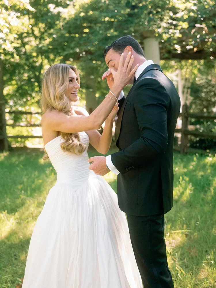 Groom wiping away tears during an emotional first look with bride in a sunlit garden, part of a seamless wedding morning timeline