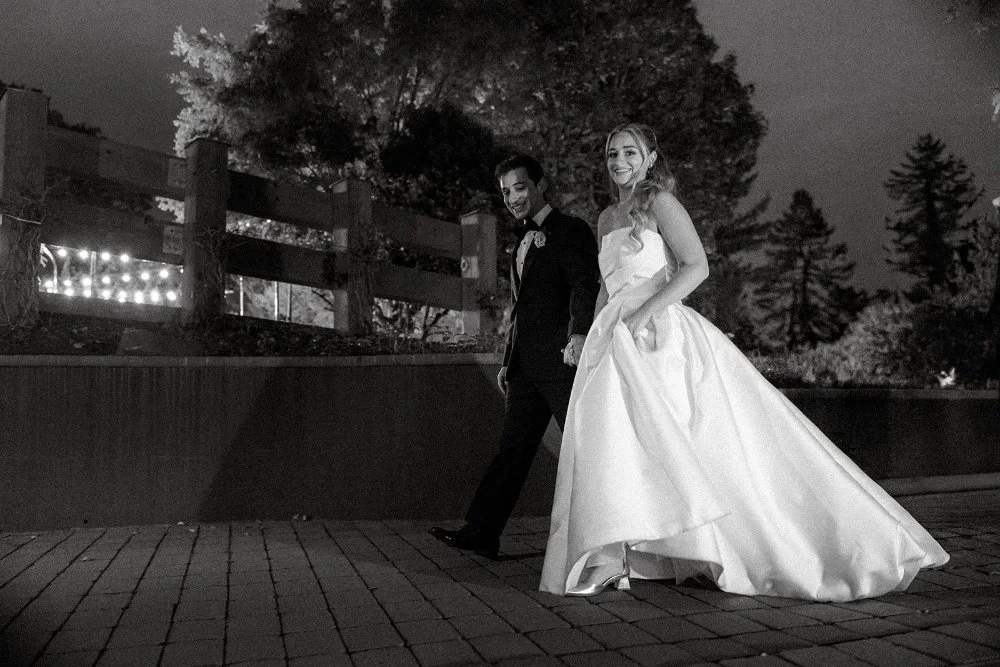 Bride and groom walking together at night along a lit pathway during Tarrytown NY outdoor wedding