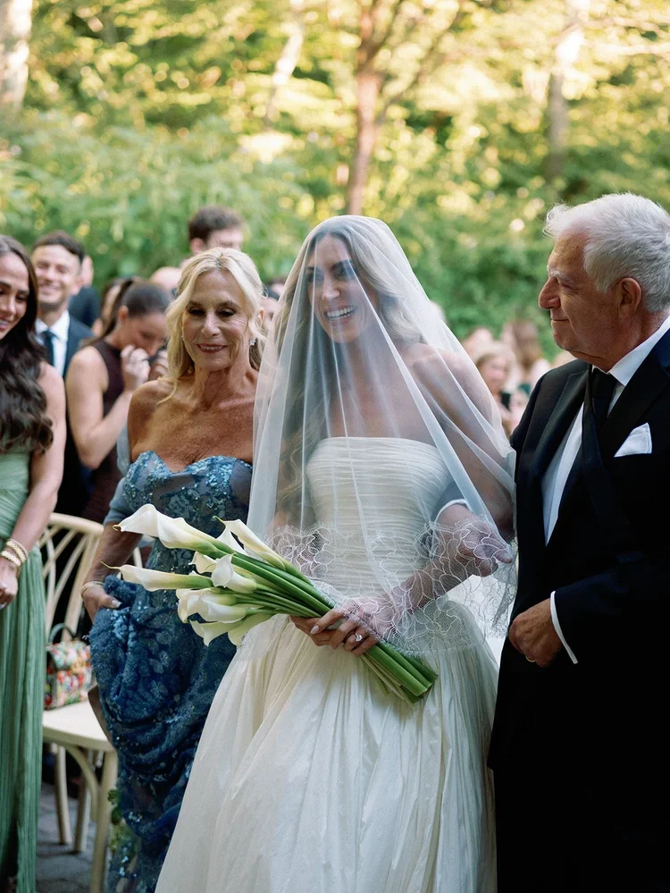Bride arriving at her outdoor ceremony escorted by her parents, one of the most meaningful wedding ceremony ideas for family-focused celebrations.