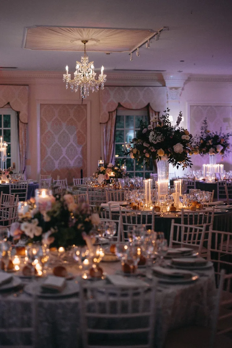 Sophisticated evening wedding reception with candlelit tables and florals, showcasing how a wedding planner checklist brings ambience and logistics together seamlessly.