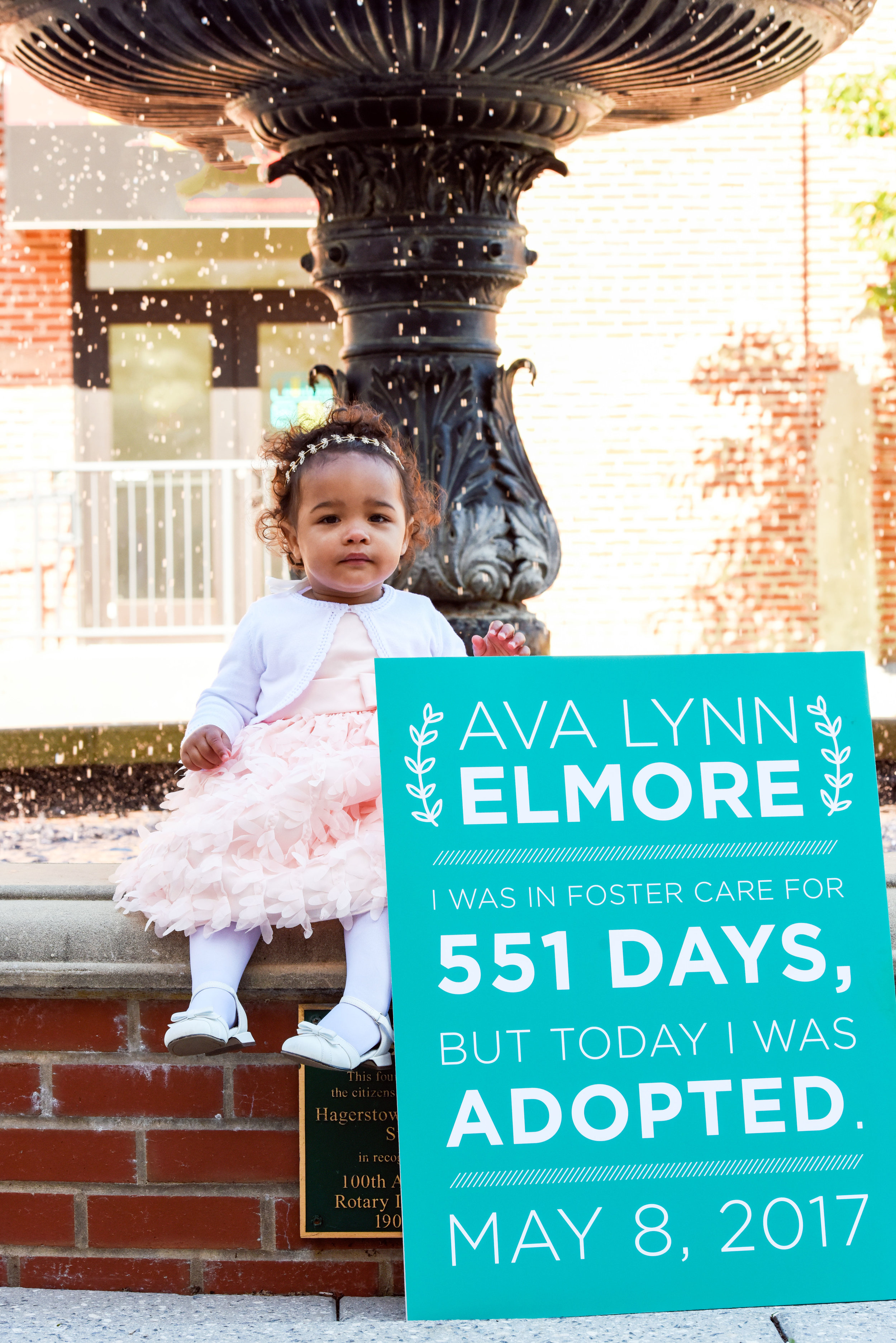 Ava with sign on fountain.jpg