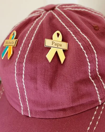 You guys are so clever! We love it when you send us photos of how you wear your awareness ribbons. No offense to all the other companies, but our customers are way more creative than yours. Our custom awareness ribbons are our signature product. We are the only company in North America to offer customizable awareness ribbon pins, without having a minimum order quantity. That means you can order just one custom awareness ribbon if that's all you want. We are so proud to offer this product because we believe that putting a name to an illness or cause is what connects others to it. We have seen first hand how one custom awareness ribbon can raise awareness and support for a person or cause throughout an entire community. 