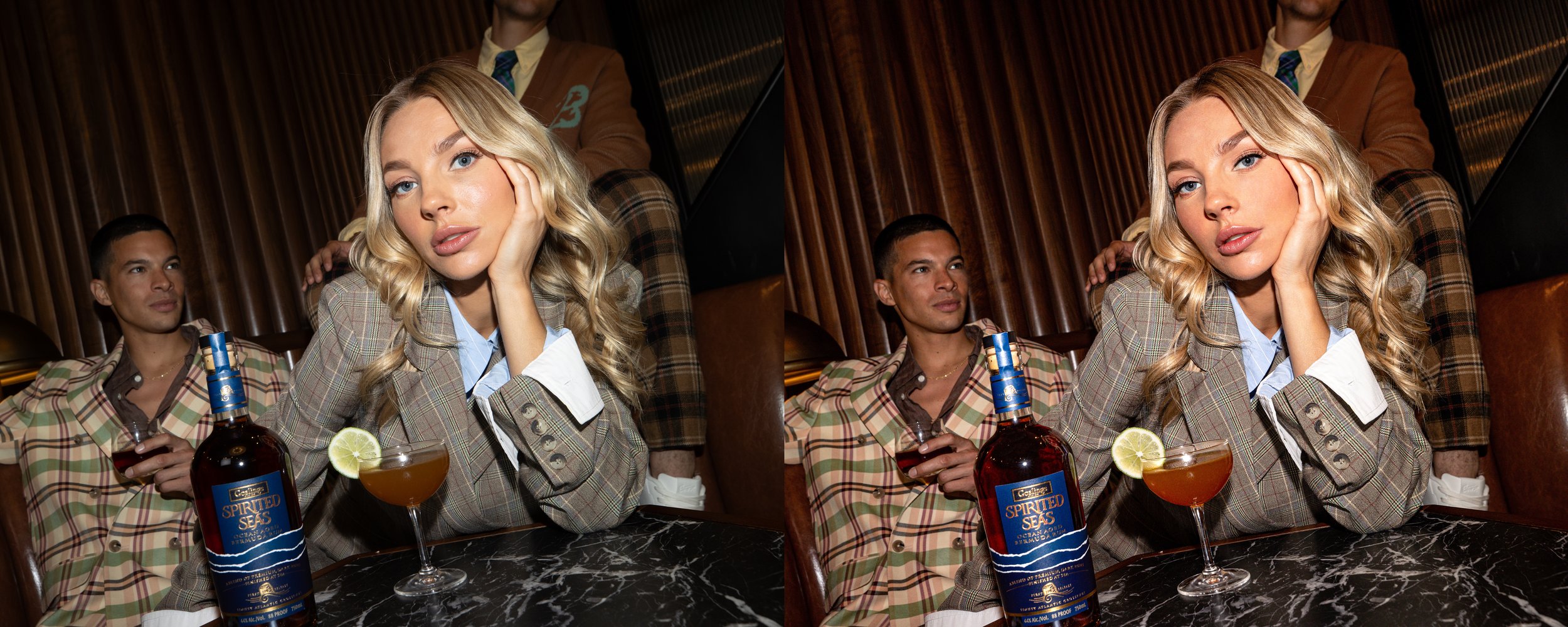 Young woman with blonde hair, wearing a plaid blazer, resting her face on her hand, sitting at a table with a cocktail and a bottle of spirits, in a dimly lit setting. Two men in plaid jackets sit behind her, one holding a drink.