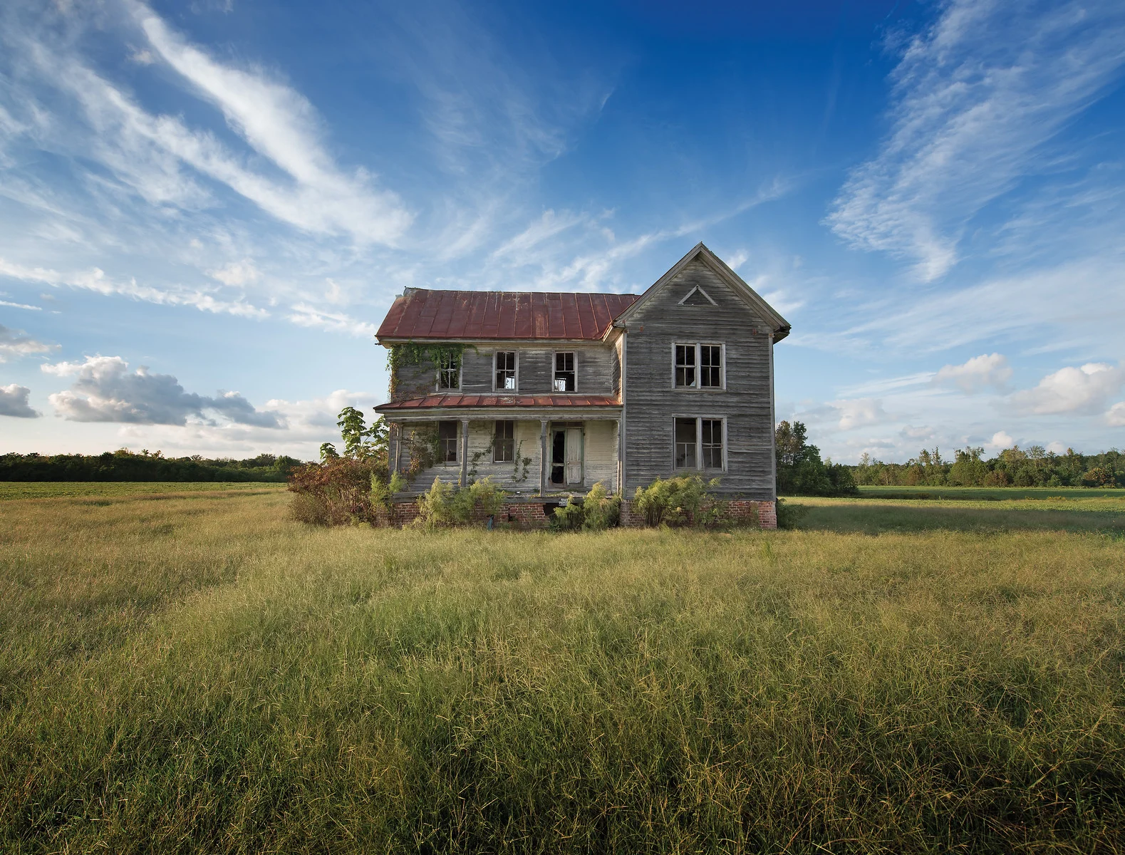 An abandoned Virginia farmhouse is bathed in the summer's late afternoon soft light.