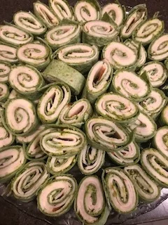 Turkey-pesto-provolone pinwheels on a spinach and herb wrap...
