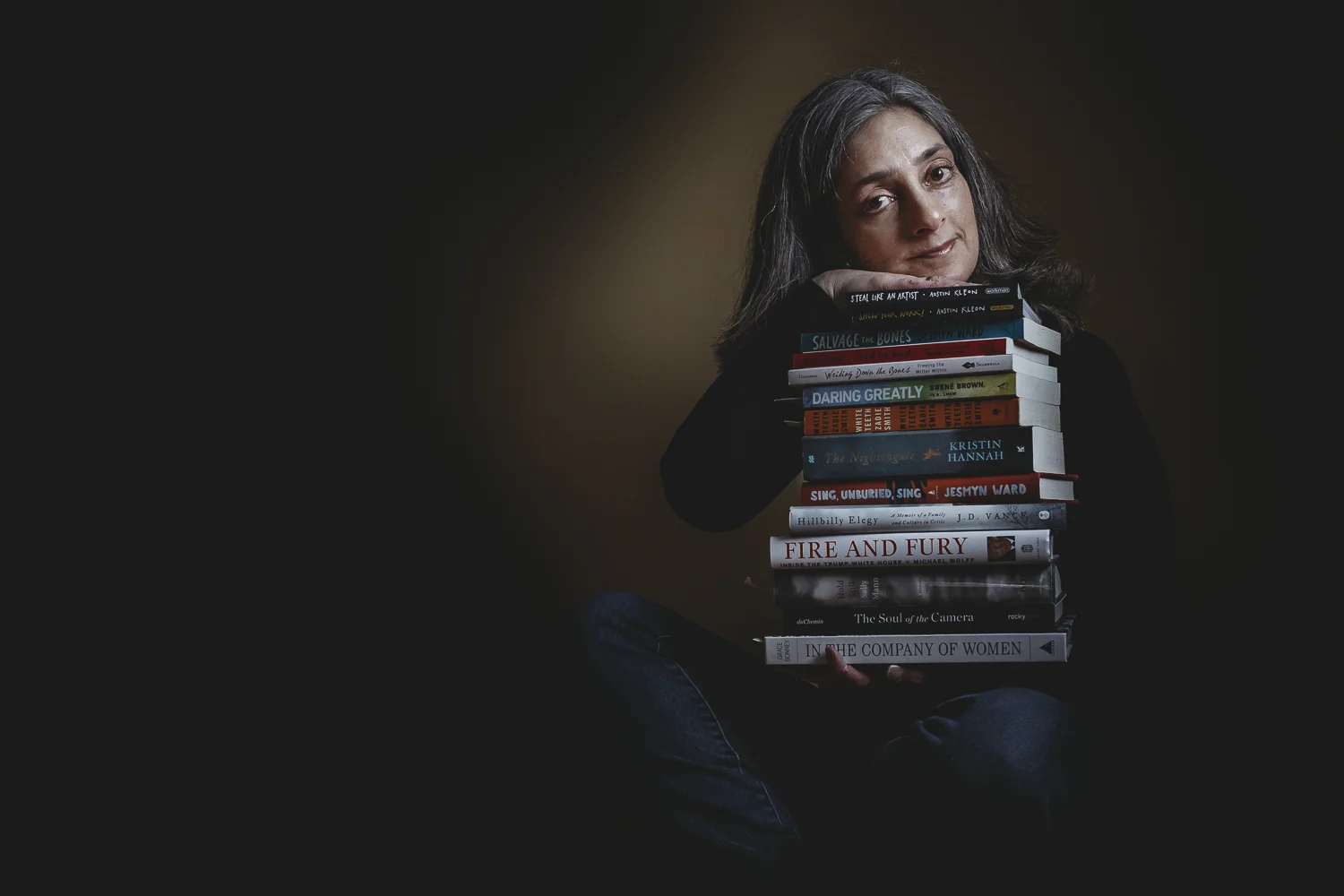 2.6.18 It's always a little easier to look directly at the camera if you have a few props. Reading is one of my passions, and with so many great books and so few hours in the day, I always have a huge stack of books that I'm either reading or hope to be reading soon. This is a portrait I have wanted make for a while, because I think you can tell a lot about a person by the books she has on her bookshelf.
