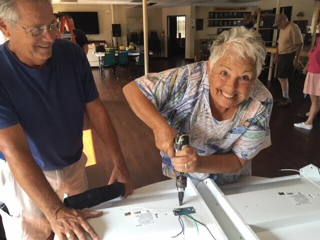John Hukill and Susan Young getting light fixtures drilled and wiring for installation (HBYC’s Susan the Riveter)