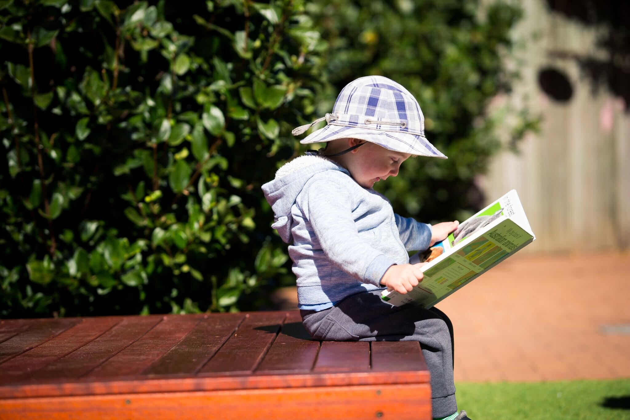 Toddler Reading Book In A Country Garden