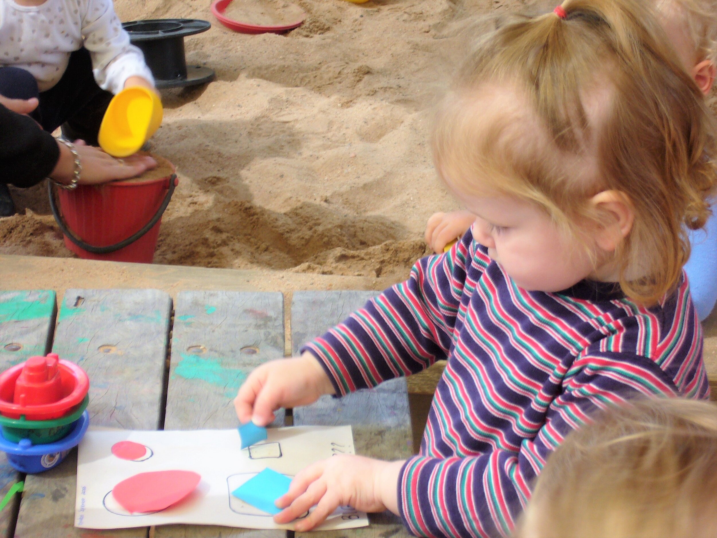 Toddler Girl Performing Sand Paper Shape Activity