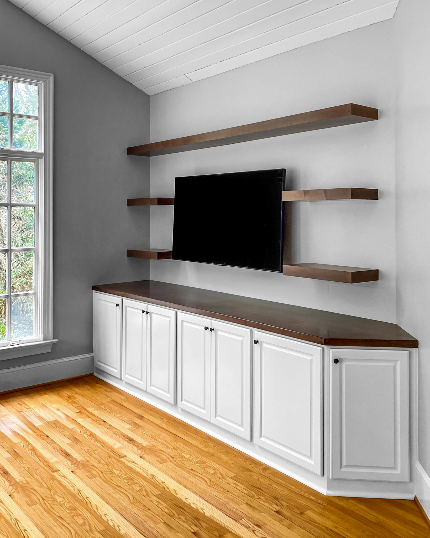 Custom cabinet entertainment center, wall mounted with floating shelves and angled based