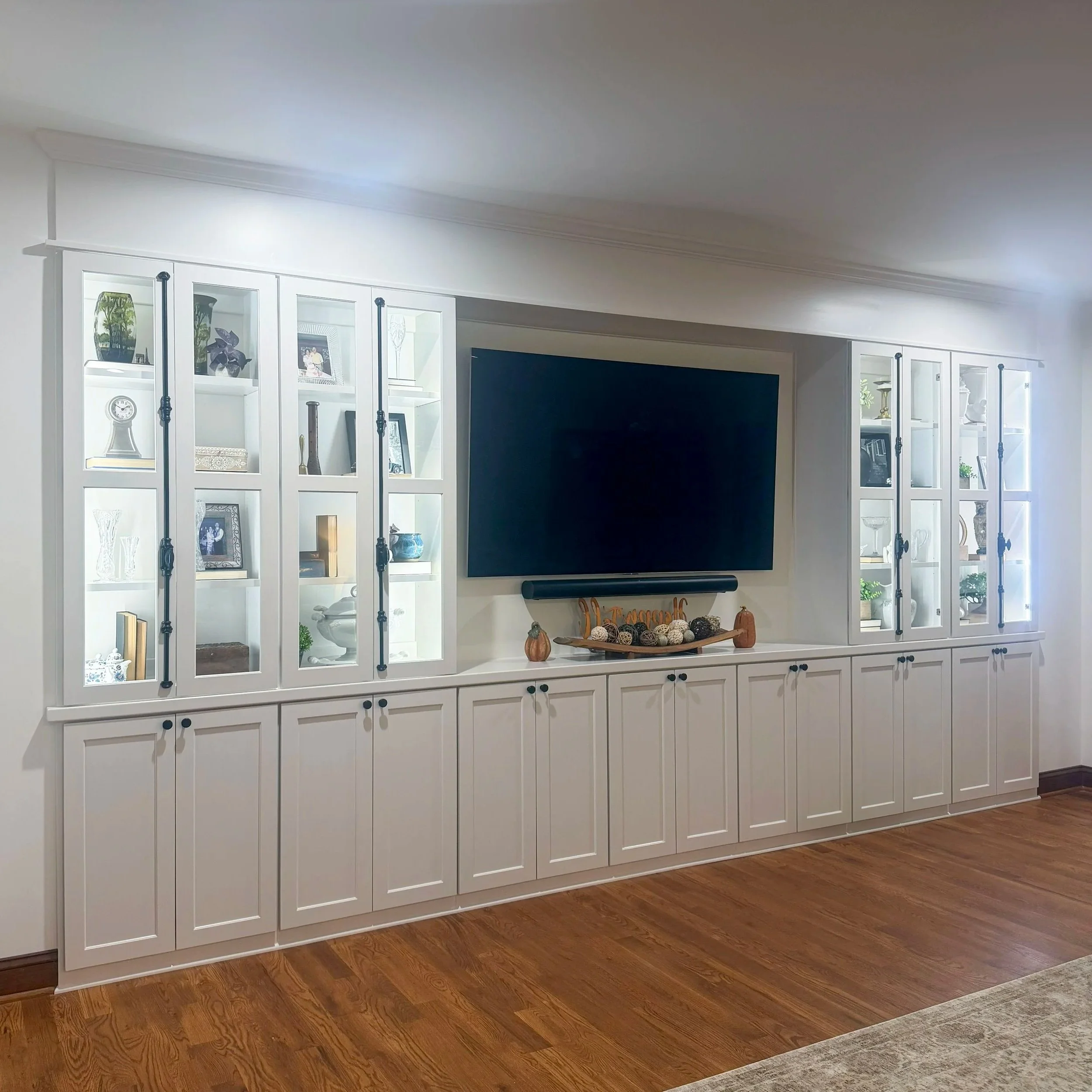 Built-in entertainment center with glass door uppers and cremone bolts.