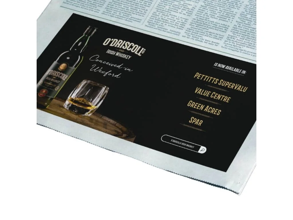 Advertisement for O'Driscoll Irish Whiskey featuring a bottle and a glass of whiskey, with text indicating availability in several locations, and a search bar at the bottom.
