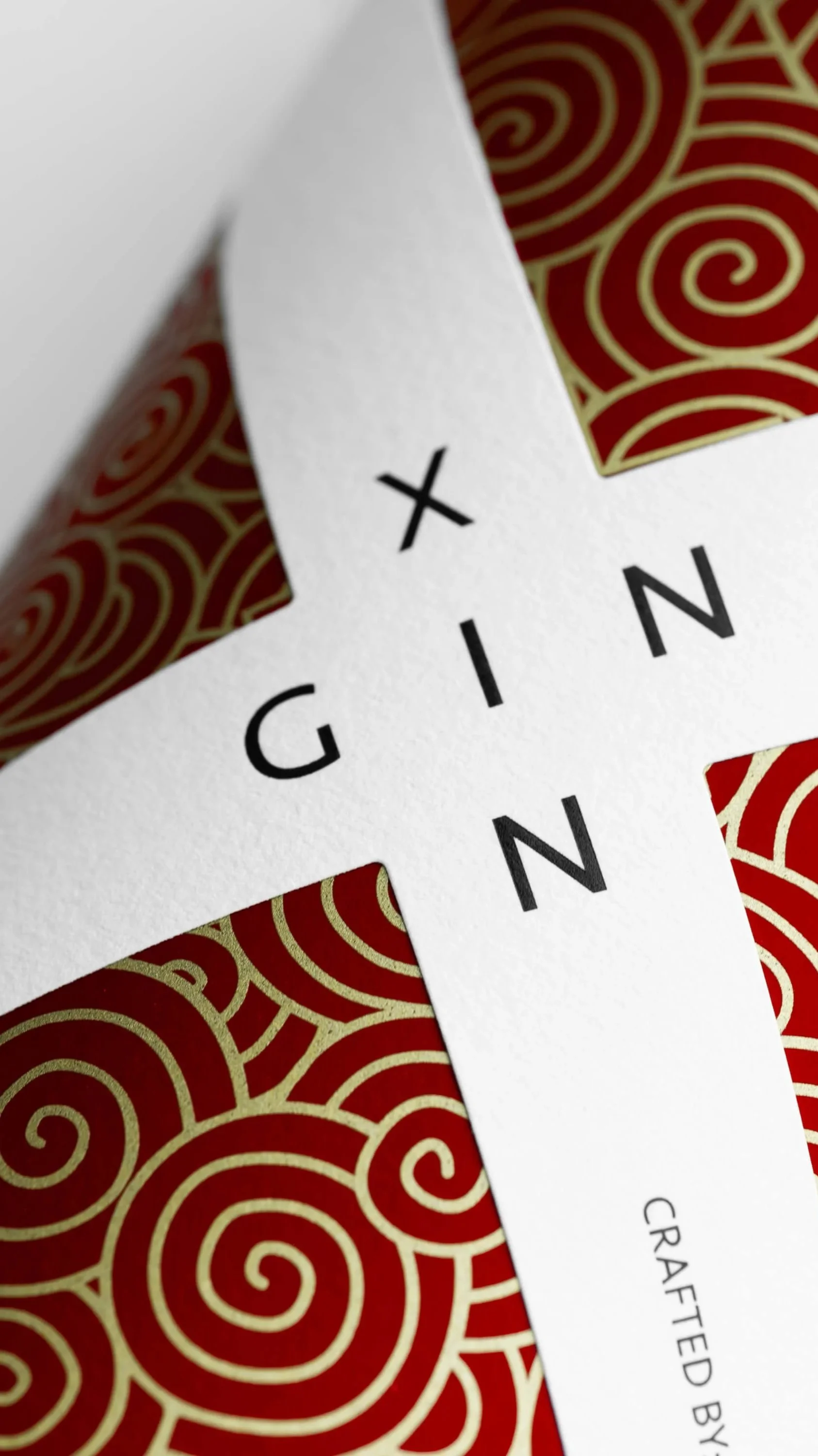 Close-up of a gift box with a white cross-shaped label that has the word 'GIVING' printed on it, and a red and gold swirl pattern inside the box.