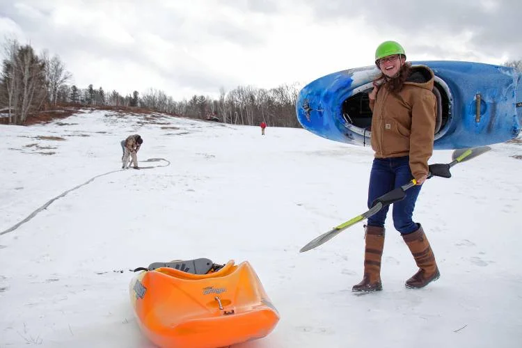 The author's friend and volunteer Orli Gottlieb finishes up a couple test-runs kayaking down the Veterans Memorial Recreation Ski Area in Franklin on Friday, the day before the Boat Bash Snow Crash event. Elodie Reed—Concord Monitor
