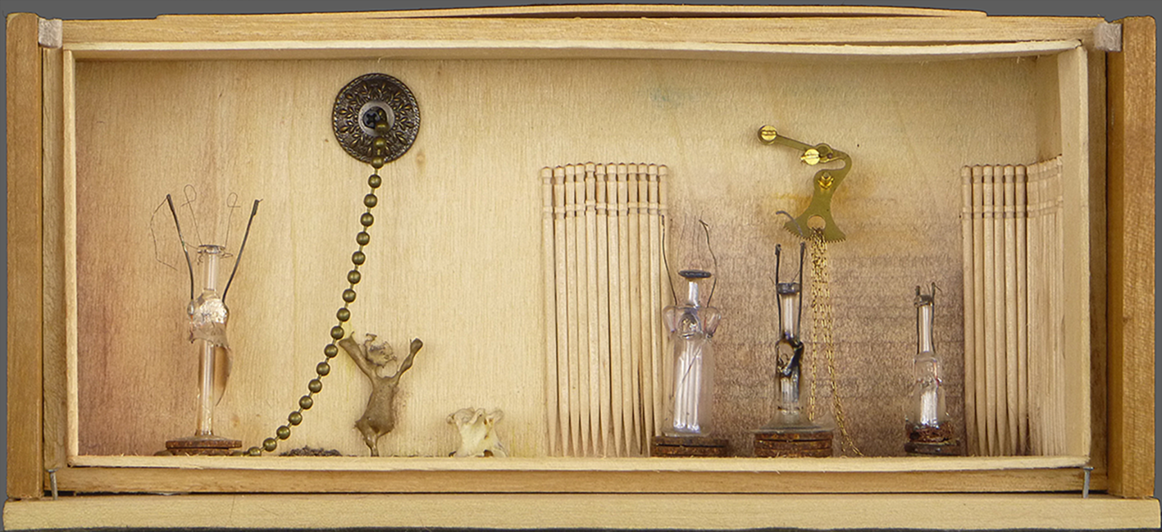   Free Association   2014, 9.5"w x 4.25"h x 3.5"d. Mixed media, including wood, various metals, bronze spill, glass, bone, lightbulb filaments, $210. 