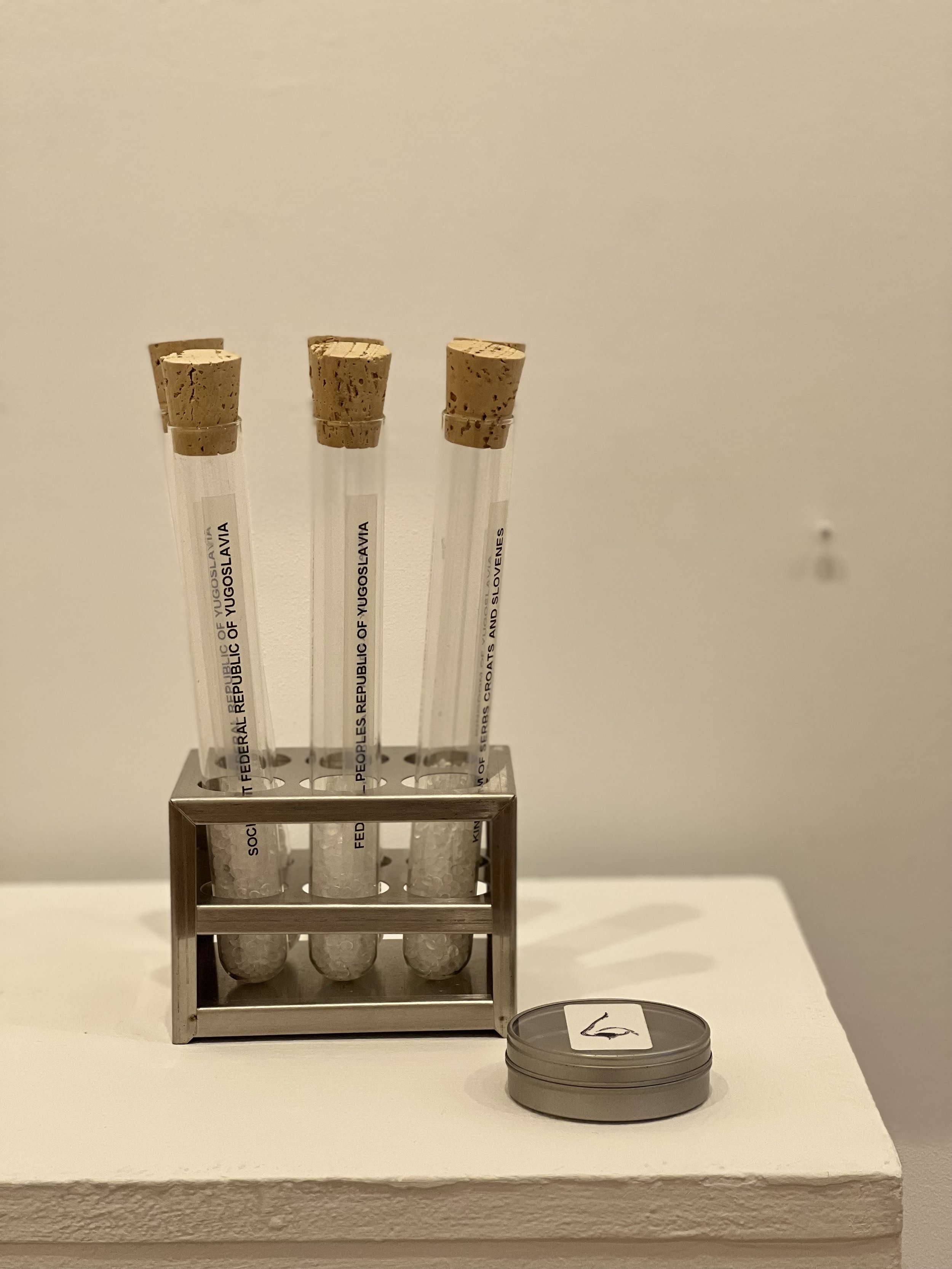   Scents for Forgotten Countries , 2022  Glass test tubes, cork stoppers, stainless steel rack, scents  9.5 x 4.5 x 3 inches   $450.   Six clear glass test tubes with corks and displayed on a stainless-steel lab rack.  