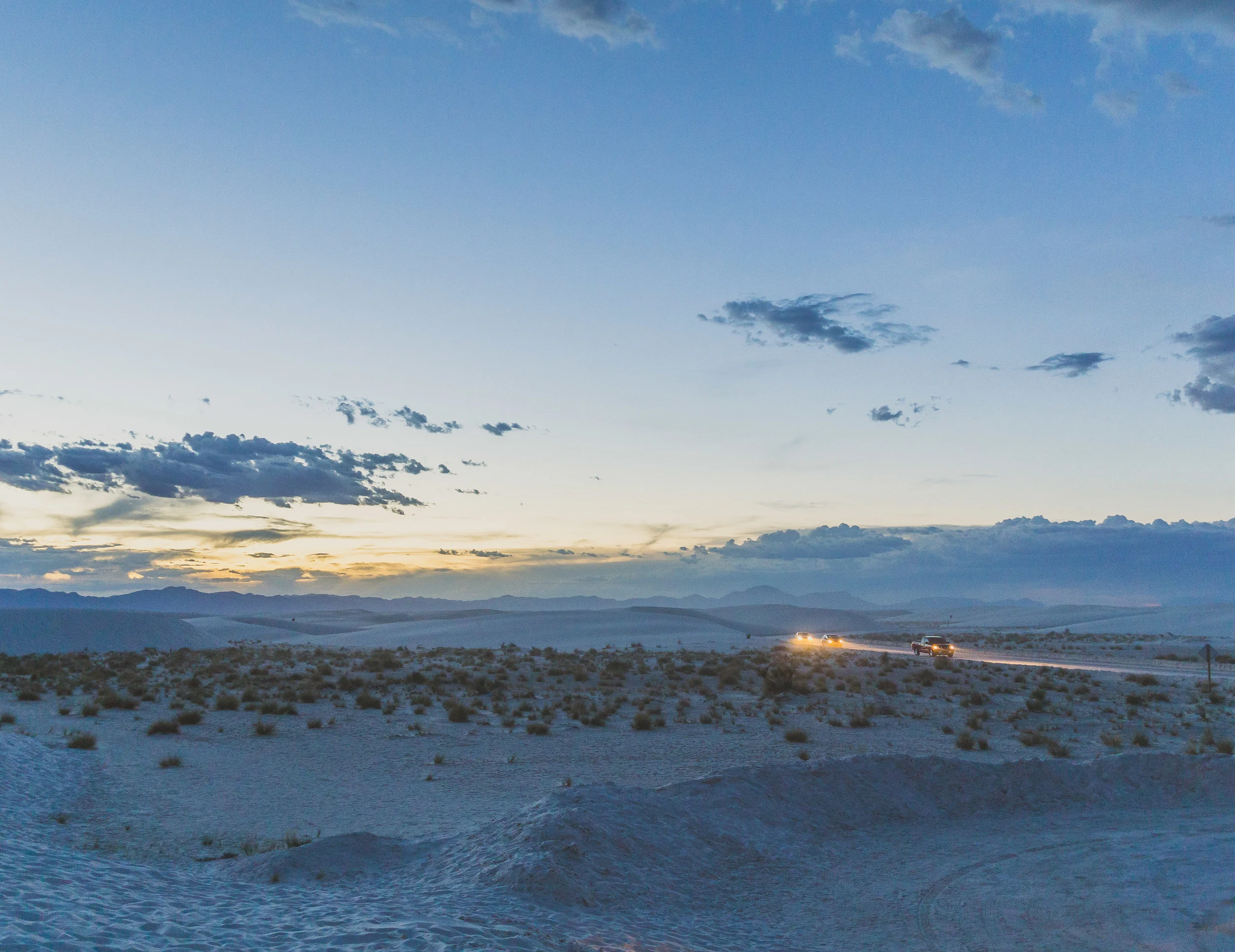 The few cars left in the park exit along the sand road in the twilight just before closing time.&nbsp;