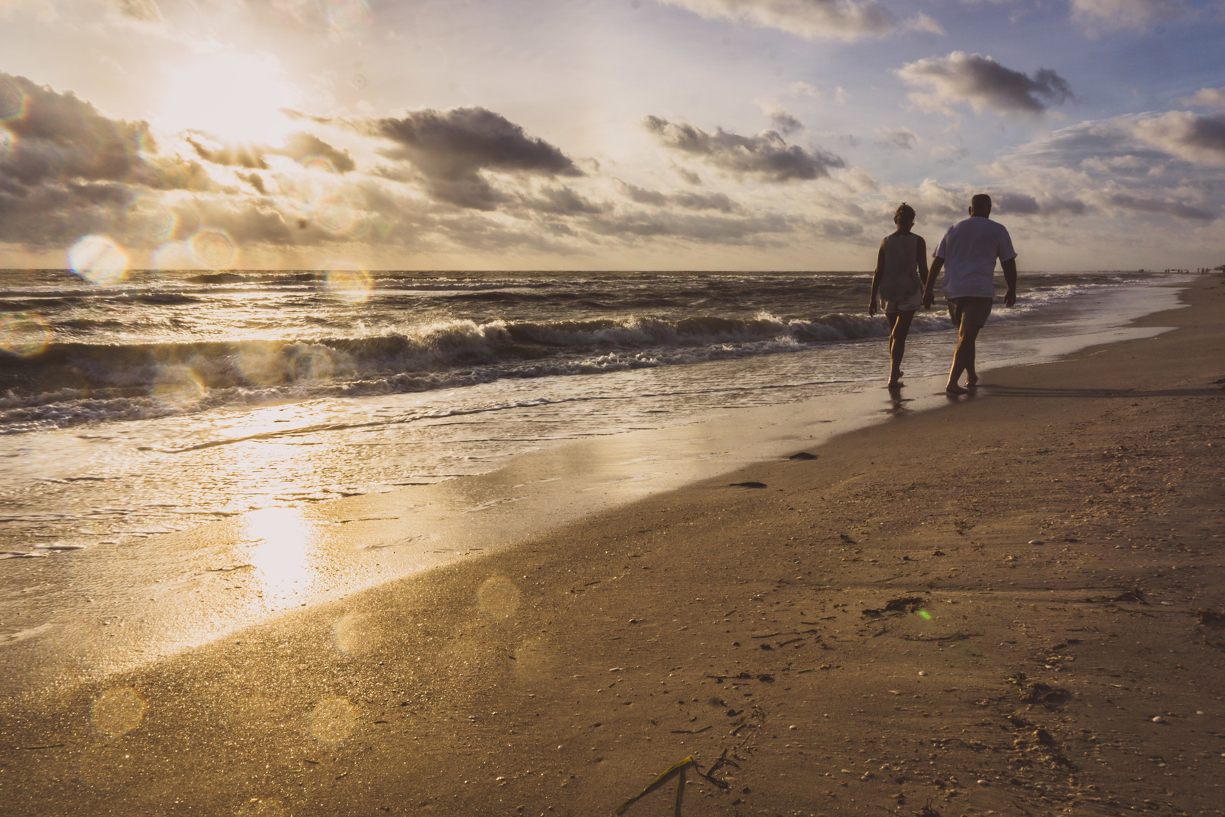 st. pete couple walking in sea spray sunset.jpg