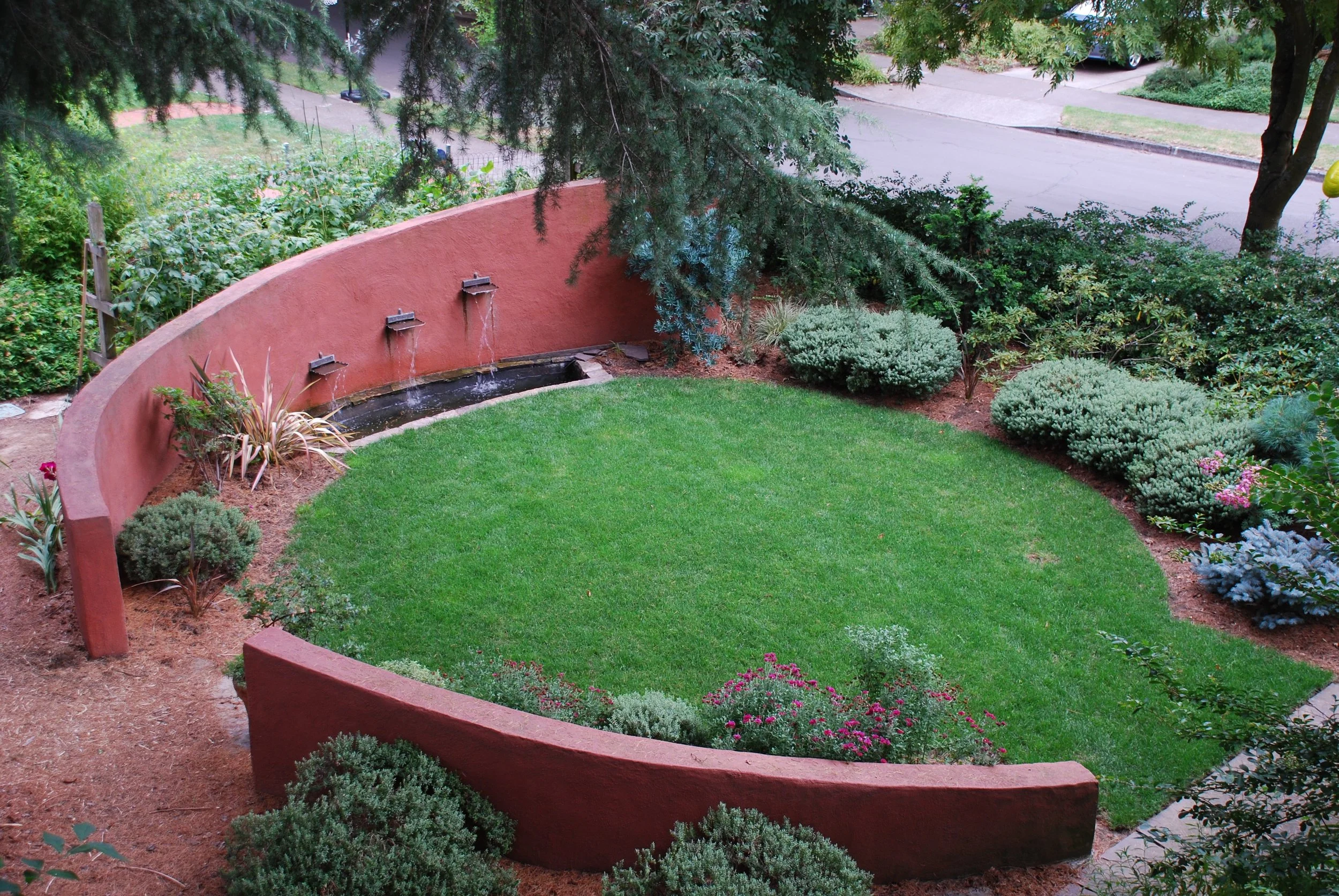 Gregg House 2 . Stucco wall with water fountain. The wall starts at six feet high and tapers down to two feet. Adds some privacy.