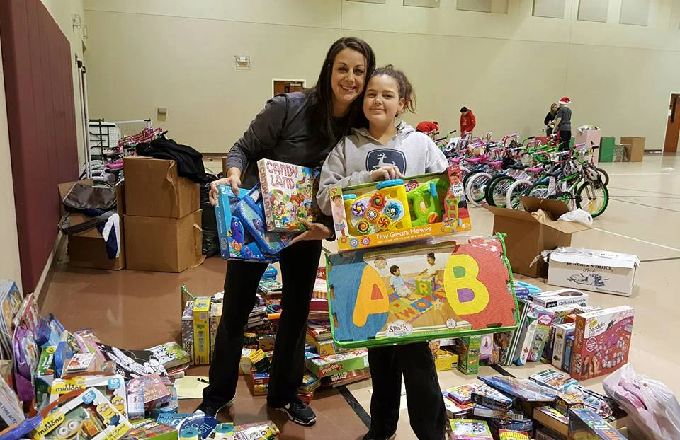 Fayette County Chamber of Commerce Executive Director Mendi Donnelly (center) helps fill Christmas food boxes for Fayette Cares.