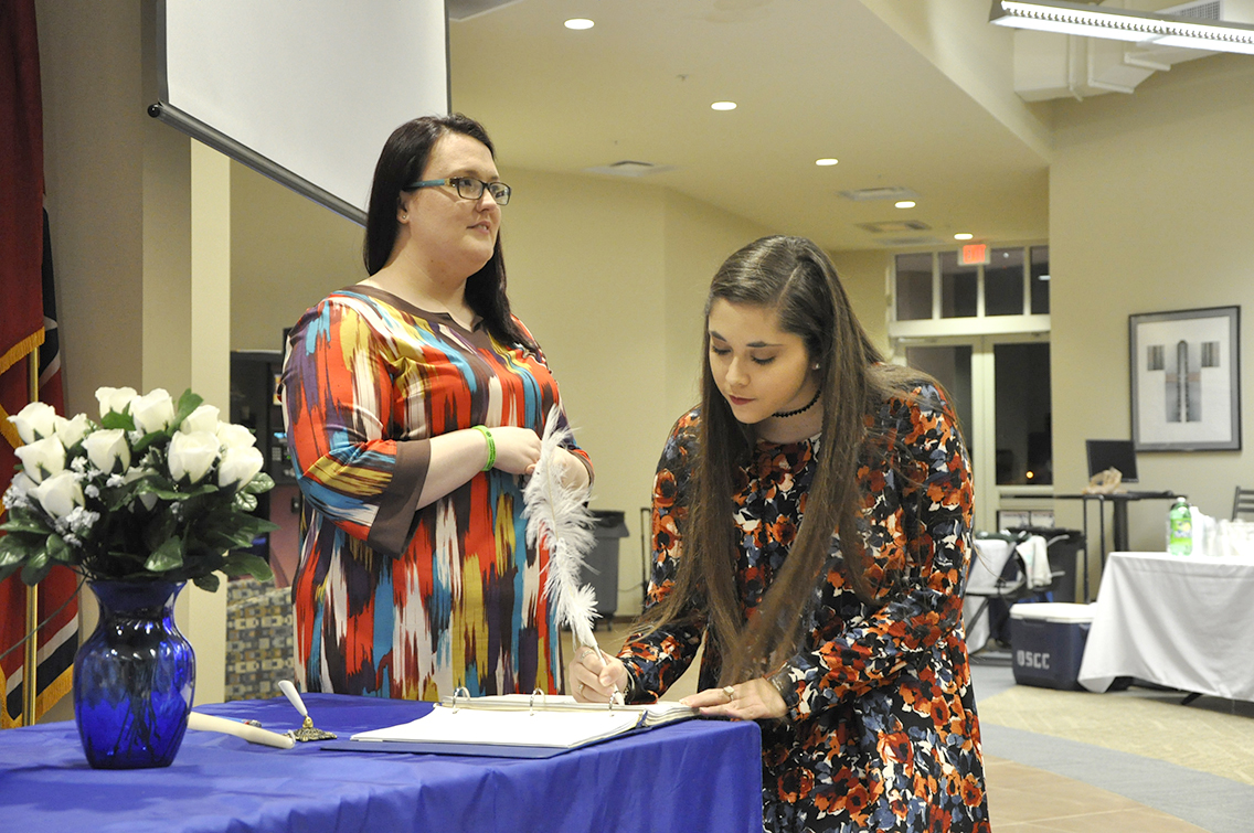 PTK Inductee Brianna Burse of Halls (right) signs her name on the ledger during DSCC’s 2017 Induction Ceremony March 17. Also shown is PTK member Rachel Isaak of Gates (left).