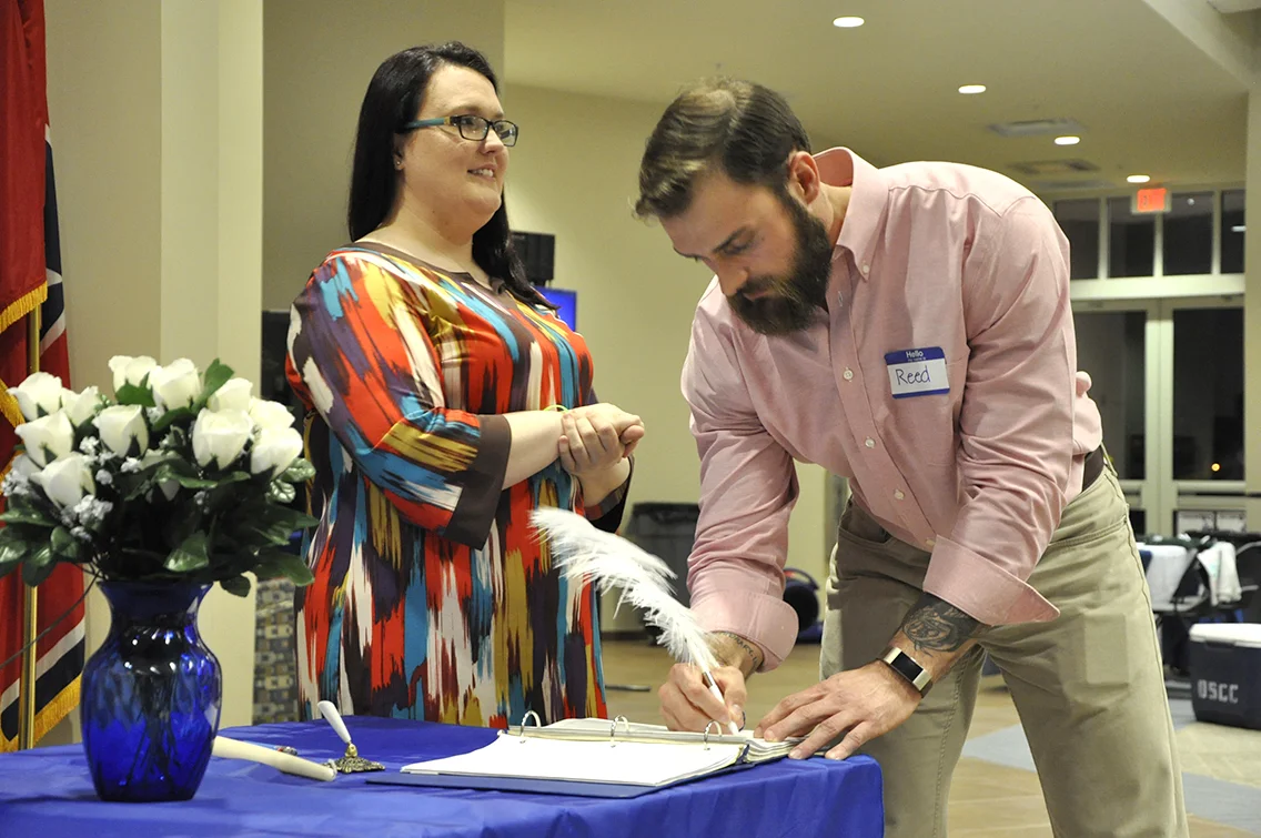PTK Inductee Reed Daniels of Dyersburg (right) signs his name on the ledger during DSCC’s 2017 Induction Ceremony March 17. Also shown is PTK member Rachel Isaak of Gates (left).