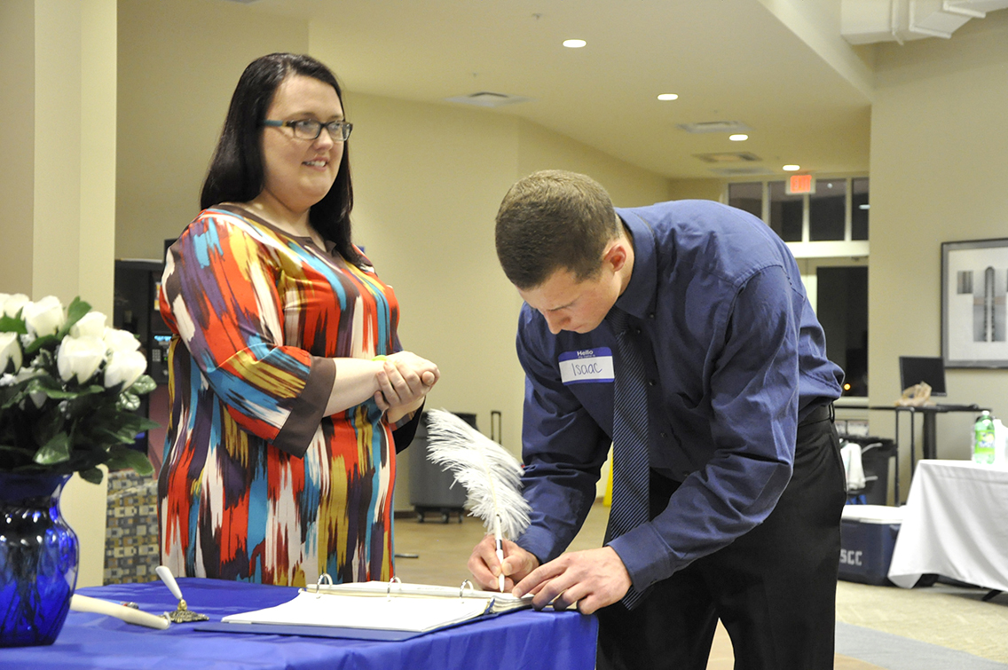 PTK Inductee Isaac Mecklin of Munford (right) signs his name on the ledger during DSCC’s 2017 Induction Ceremony March 17. Also shown is PTK member Rachel Isaak of Gates (left).