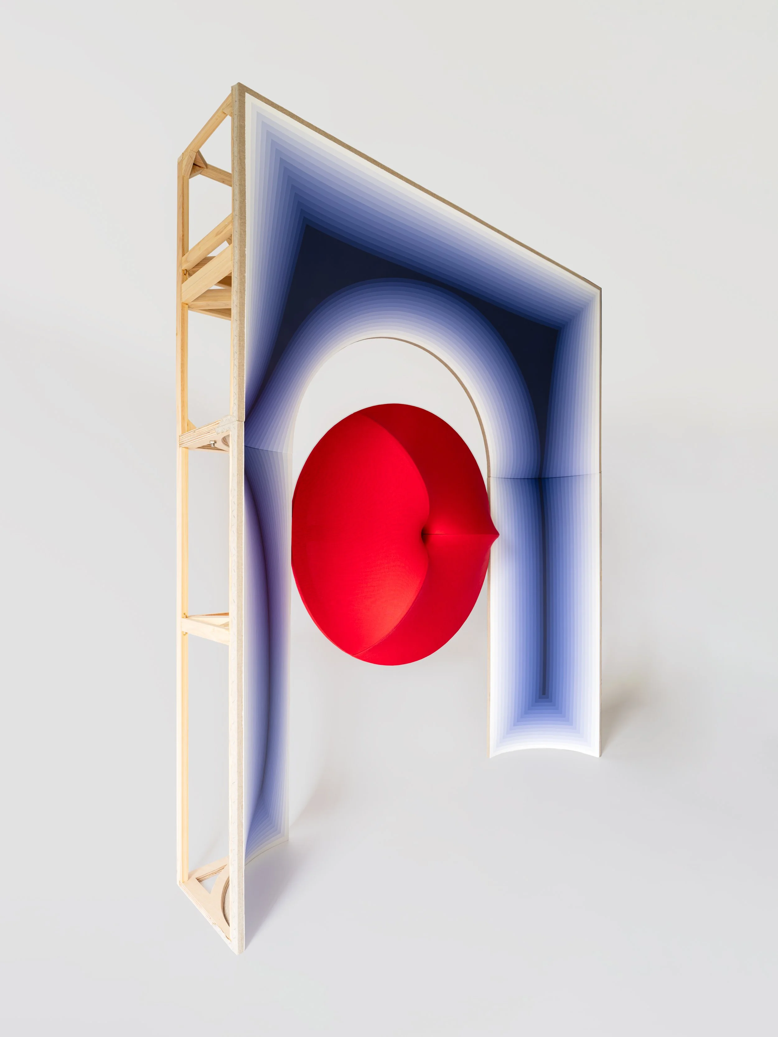   Concept Description    SUSPENDED GRAVITY  contains a paradox: a falling body held in suspension.  At its centre, a red form recalls Newton’s apple, yet its fall is arrested within a restraining arch. The same form also reads as a celestial body, as