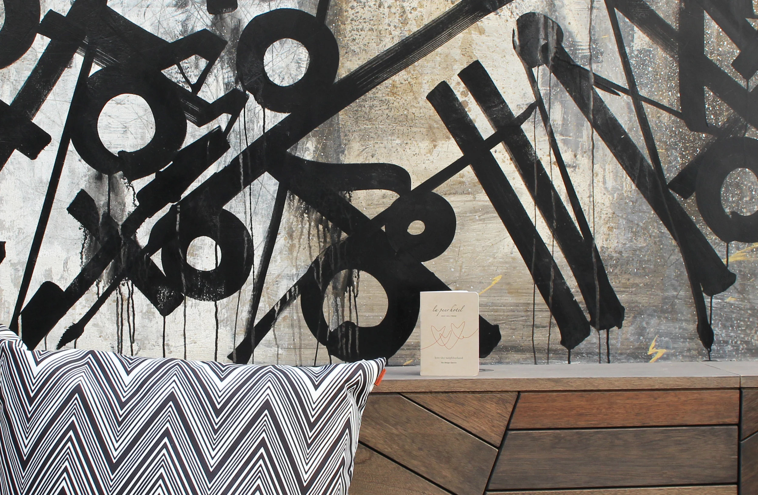 Passport photographed by the Retna mural inside the La Peer Hotel