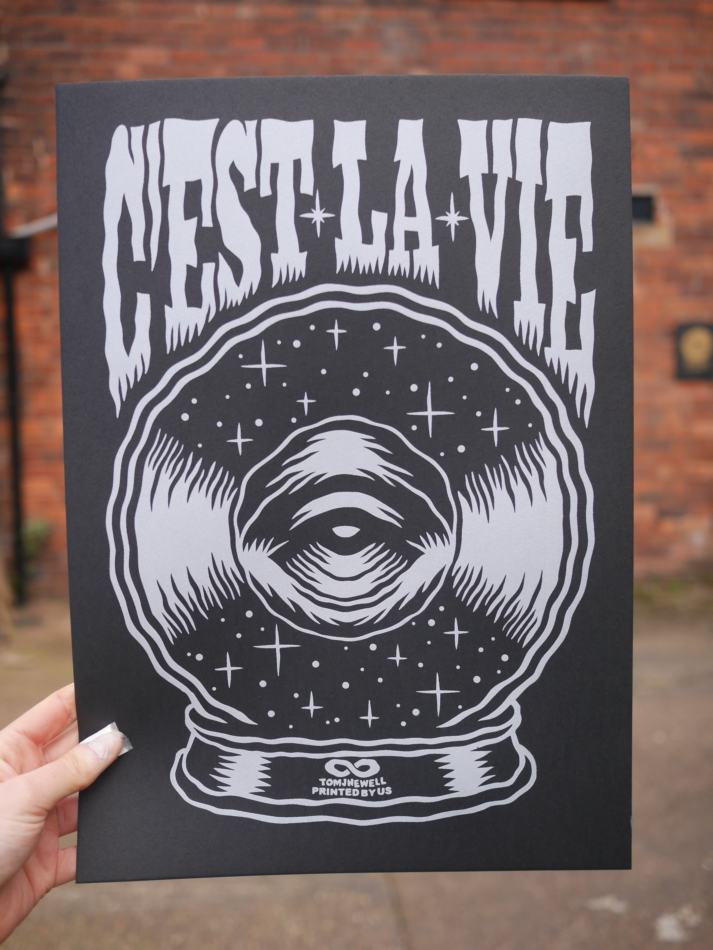 Freshly printed metallic silver ink on Black 300gsm G.F. Smith card.