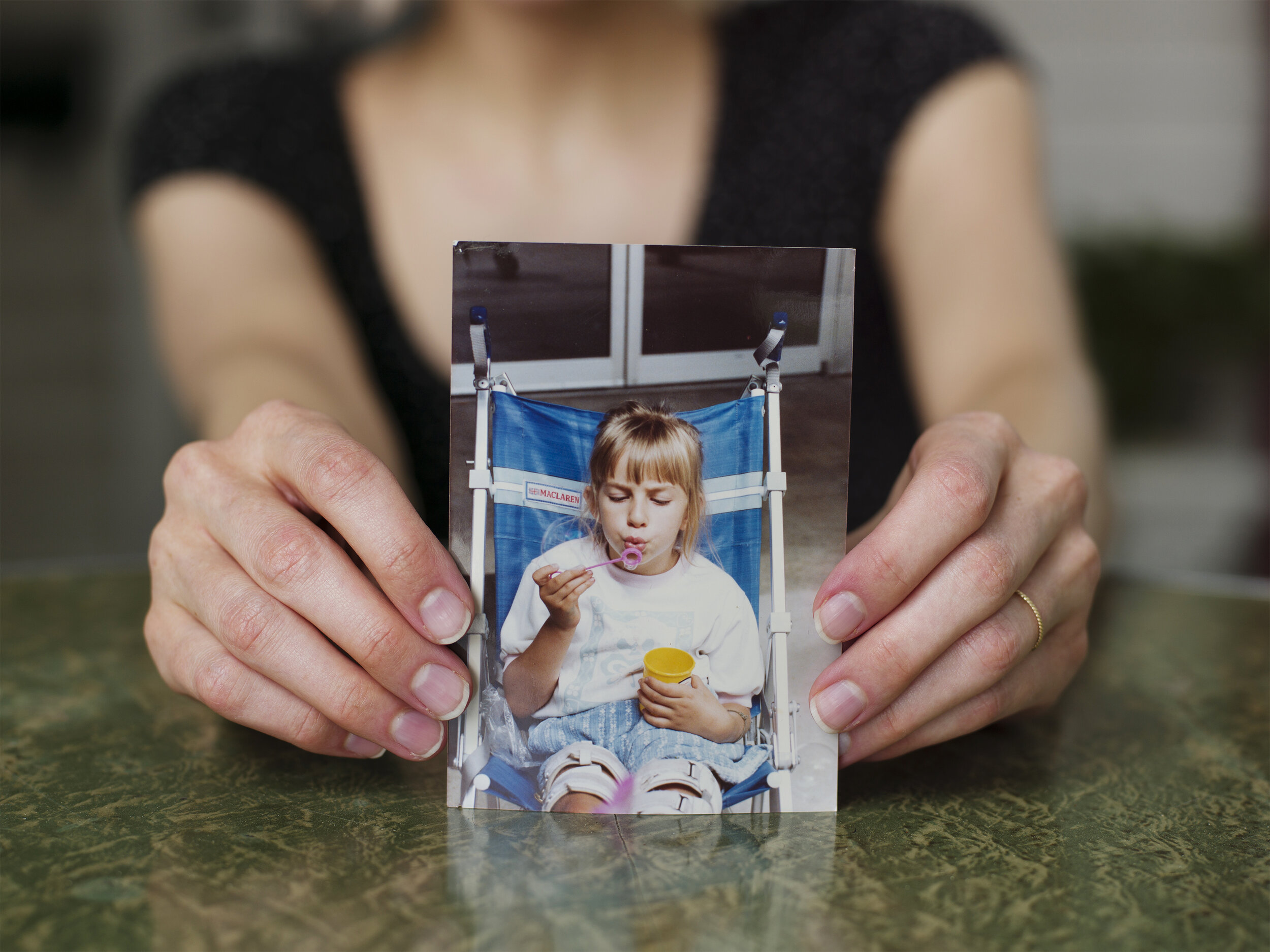  Rebekah Taussig, author of “Sitting Pretty: The View From My Ordinary Resilient Disabled Body,” holding a photograph of herself at age 5, for  TIME , 2020. 