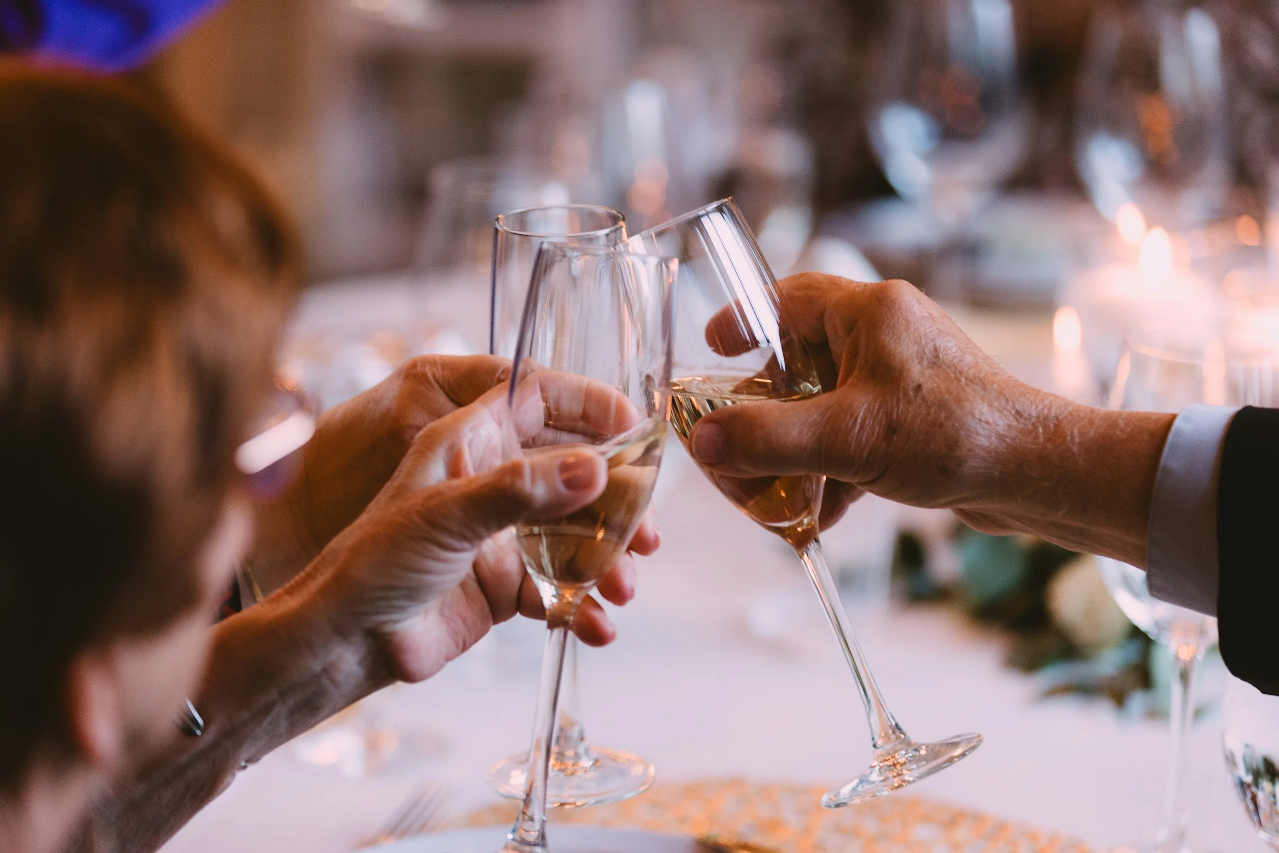 People clinking champagne glasses in a toast at a celebration event.