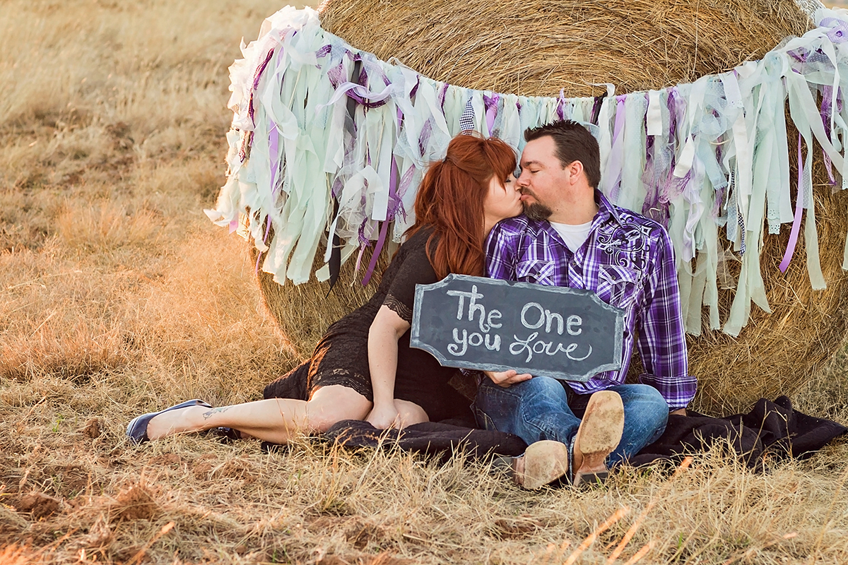 Couple in lace and plaid kissing by a haybale.jpg