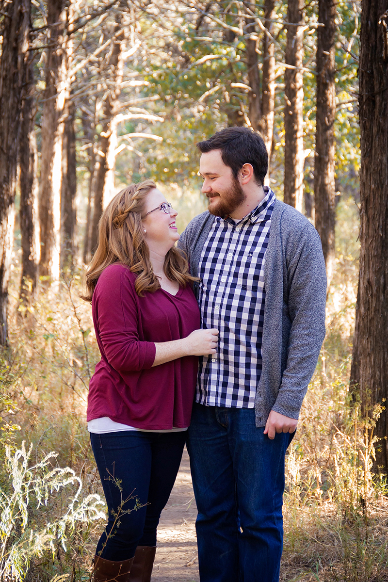 Cute couple in purple and blue plaid standing in forest.jpg